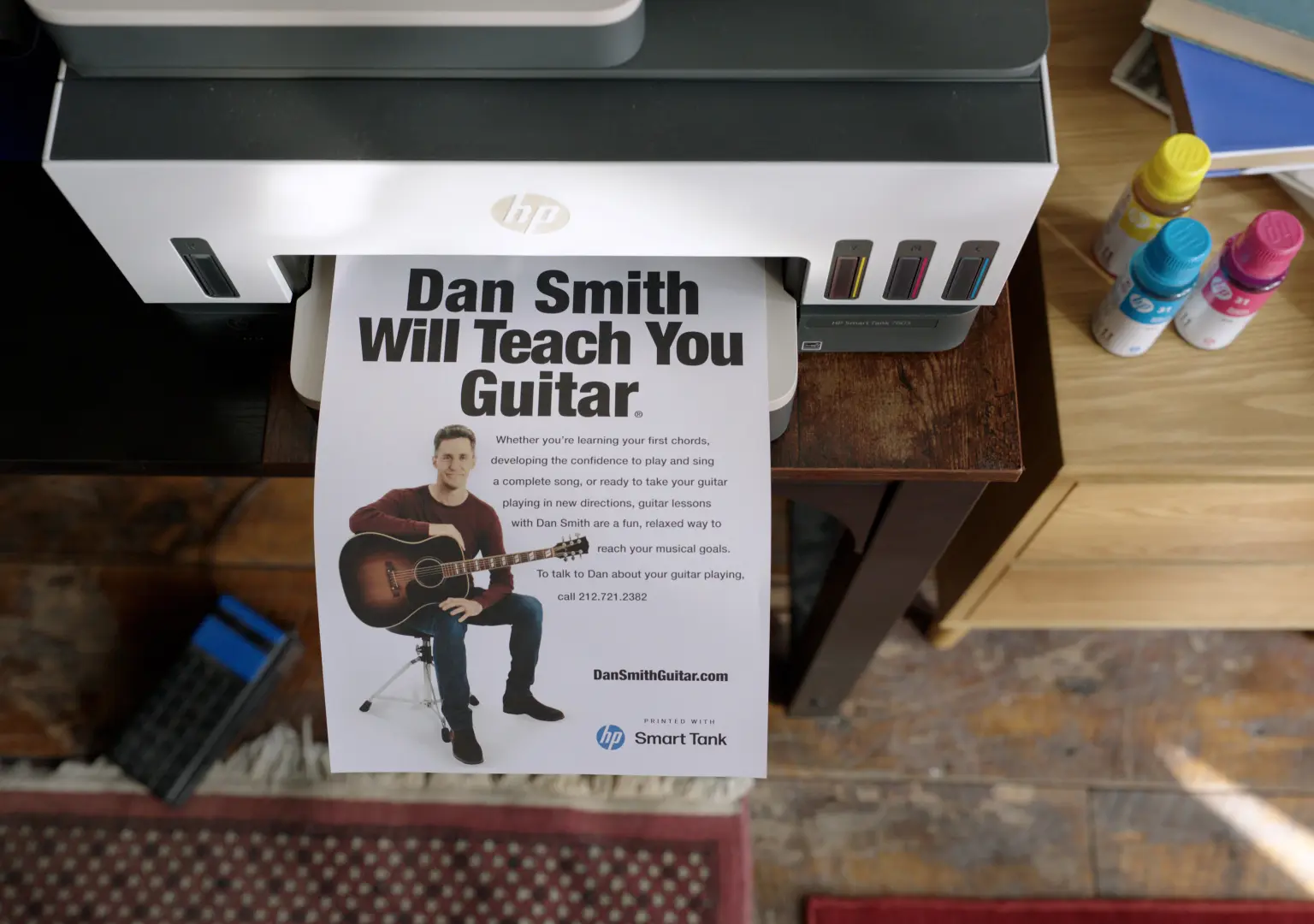 A freshly printed Dan Smith guitar lesson flyer coming out of a printer